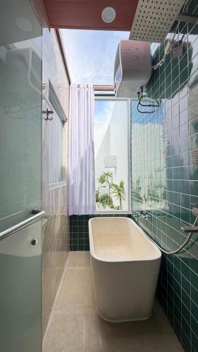 a bathroom with a tub and a window at Zeman Villa in Padang