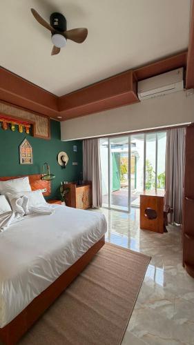 a bedroom with a large bed and a ceiling fan at Zeman Villa in Padang