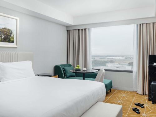 a hotel room with a bed and a table and a window at Mantra Melbourne Airport in Melbourne