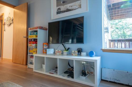a white entertainment center with a tv on a blue wall at Tolovana 3 Cannon Beach in Cannon Beach