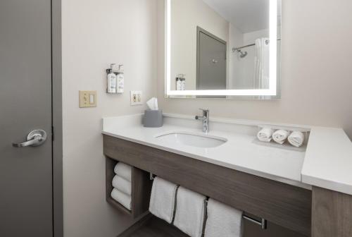 a bathroom with a sink with a mirror and towels at Holiday Inn Express - Ludlow - Chicopee Area by IHG in Ludlow