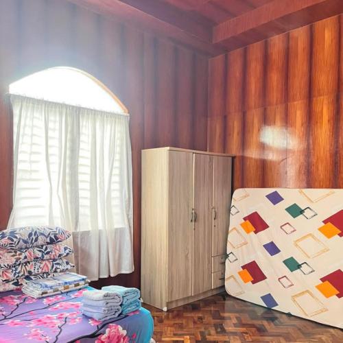 a bedroom with a bed and a dresser and a window at Alaba Vacation House w Pool and Beach Access in Mambajao