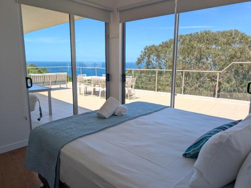 a bedroom with a bed with a view of the ocean at Rainbow Ocean Palms Resort in Rainbow Beach