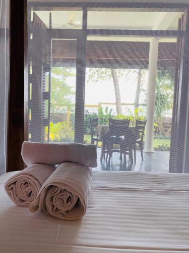 a room with two towels laying on a bed with a table at Sri Villa in Dickwella