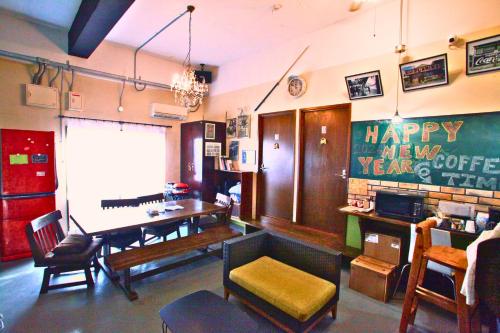 a living room with a happy new year sign on the wall at ゲストハウスゆにてぃ in Okinawa City