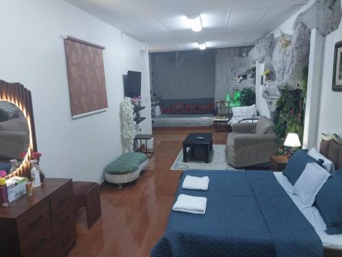 a living room with a blue bed and a couch at Studio Apartment in Abḩur al Janūbīyah