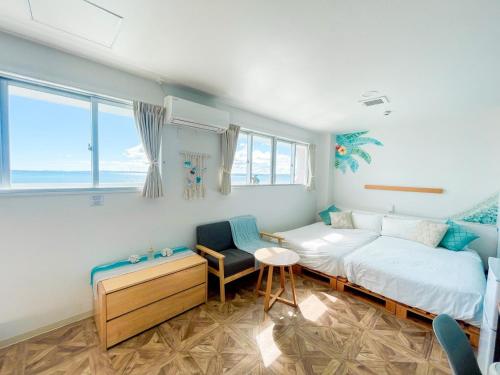 a bedroom with two beds and a table and chairs at マイビーチリゾート in Kin