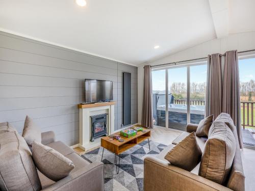 a living room with two couches and a fireplace at Billy Goat Lodge in Crossway Green