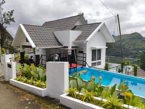 a house with a swimming pool in front of it at moonlight palace private pool villa vagamon in Vagamon