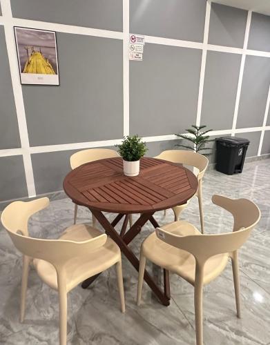 a wooden table and chairs with a potted plant on it at C&CDreamland hotel in Ipoh