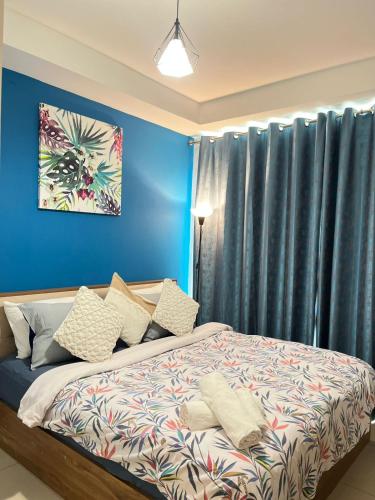 a bedroom with blue walls and a bed with pillows at 2 Bedroom Deluxe Beach Apartment Al Marjan in Ras al Khaimah