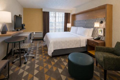 a hotel room with a bed and a desk and chair at Holiday Inn Portland- I-5 S Wilsonville by IHG in Wilsonville