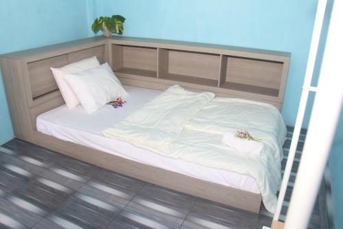 a bed with white sheets and pillows on it at Villa Lokon Tomohon in Tomohon