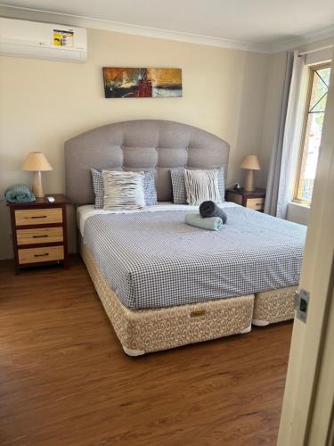 a bedroom with a large bed with a cat on it at SPACIOUS JANDAKOT HOUSE FOR FAMILY AND BUSINESs in Perth