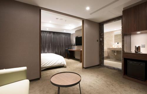 a hotel room with a bed and a table at Noble Hotel in Taipei