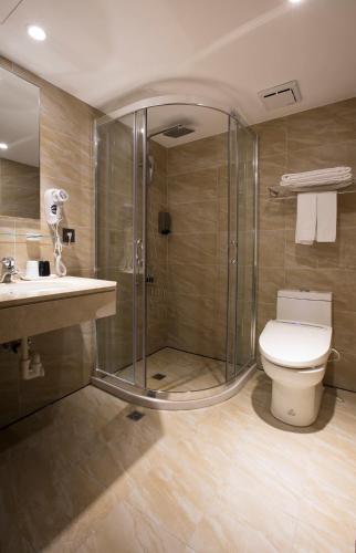 a bathroom with a shower and a toilet and a sink at Noble Hotel in Taipei