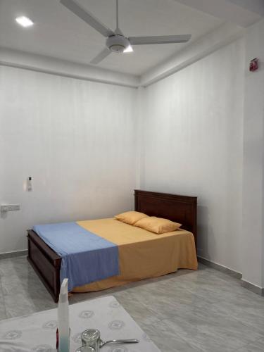 a bedroom with a bed in a white room at Nikita Homestay in Kosgoda