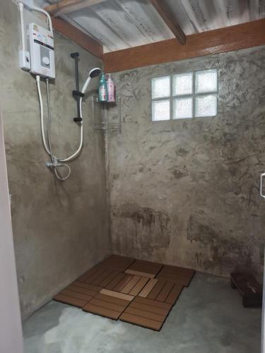a shower in a room with a wooden floor at Slow Home in Ban Yang Mae Luang