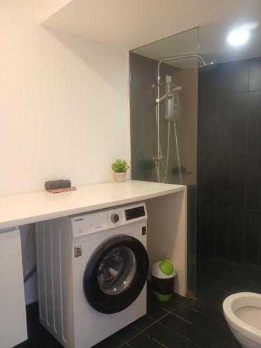 a bathroom with a washing machine under a counter at Harmonee Homes at The Hub SS2, PJ in Petaling Jaya