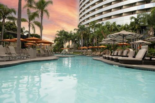 a swimming pool with chairs and umbrellas in a hotel at Marriott Marquis San Diego Marina in San Diego
