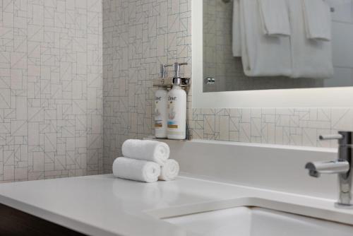 a bathroom with a sink with towels on a counter at Holiday Inn Express Windsor Waterfront by IHG in Windsor