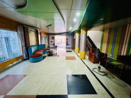 a lobby of a building with chairs and stairs at Hotel Sarbick International in Kukrāil