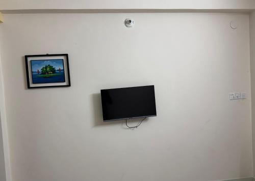 a flat screen tv hanging on a white wall at Hotel Sarbick International in Kukrāil