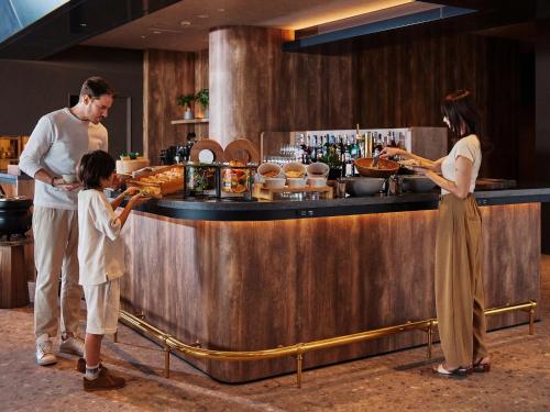 a man and a woman and a child standing at a counter at edit x seven SETOUCHI SHODOSHIMA in Shodoshima