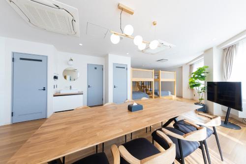 a dining room with a large wooden table and chairs at Goodsite In Oshiage in Tokyo