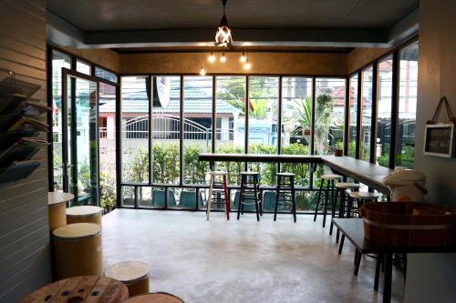 un restaurante con mesas, sillas y ventanas grandes en Area 69 (Don Muang Airport), en Bangkok