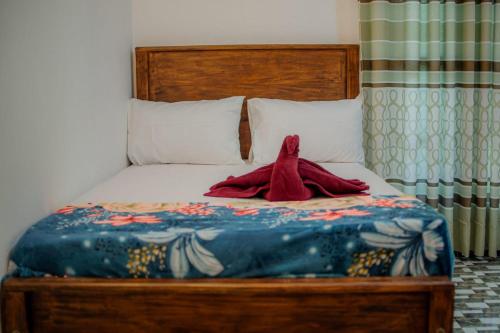 a bed with a stuffed animal sitting on it at Diyana Cottage in Sigiriya