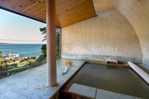 a swimming pool in a house with a view of the ocean at Isaribi (No Children) in Higashiizu