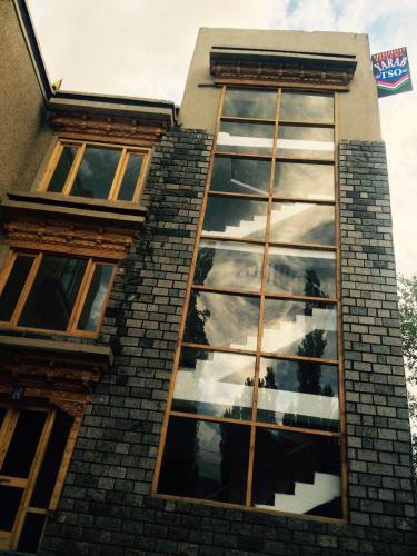 a building with a reflection of the sky in the windows at Yarab Tso in Leh