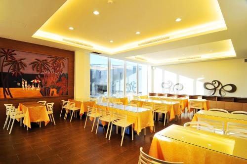 a dining room with tables and chairs and yellow tables at JinShan Sakura Bay Hot Spring Hotel in Jinshan