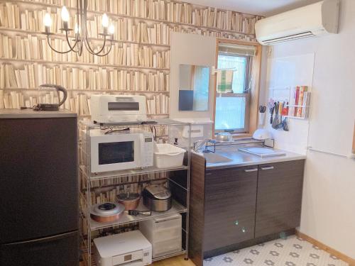 a kitchen with a sink and a microwave at 香川のゲストハウスFDroom in Takamatsu