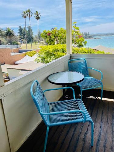 two blue chairs and a table on a porch at Bermagui Bay Beach House 2, Wonderful Beachside Location, Pet Friendly in Bermagui