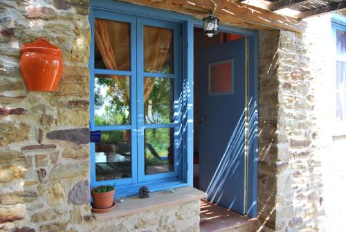 una puerta azul en una casa de piedra con una ventana en Villa Spiti Elaionas en Karfás