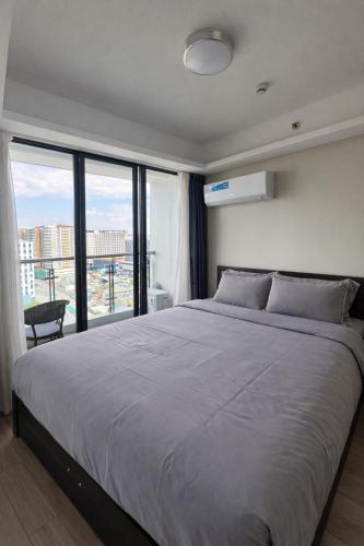 a bedroom with a large bed with a large window at LCONDOTEL Imperial Plaza Residences in Manila