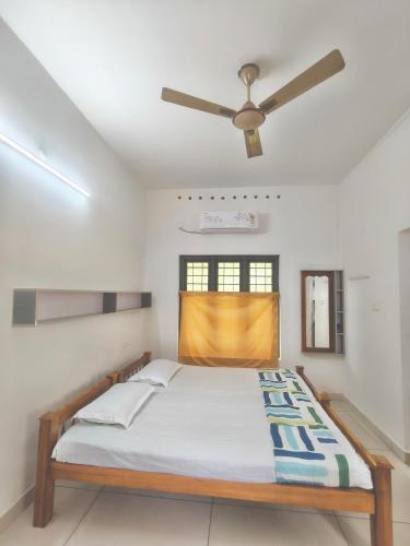 a bedroom with a bed with a ceiling fan at Lagoon lake view in Kollam