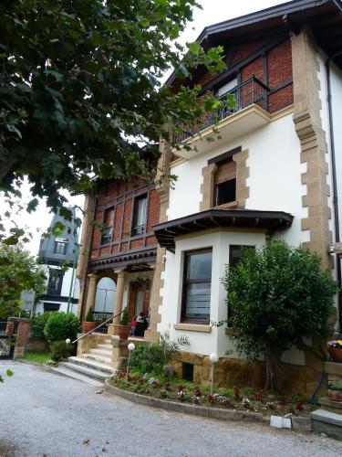 a white building with a tree in front of it at Hotel Neguri in Getxo