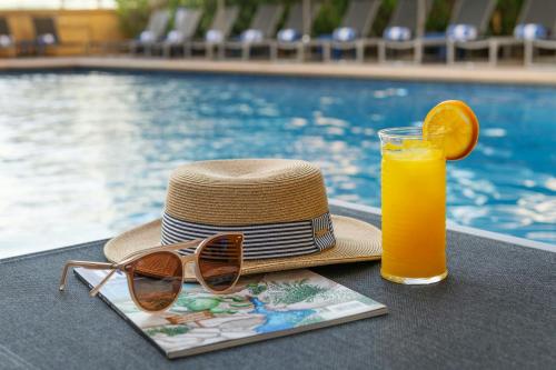 a straw hat and a glass of orange juice at Sheraton The Walk, Dubai in Dubai