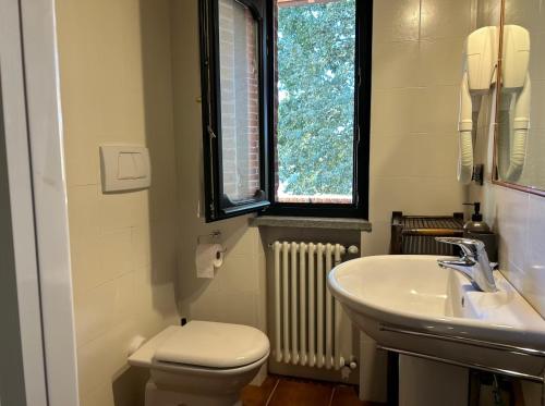a bathroom with a sink and a toilet and a window at Casa Ambrogina in Agliano Terme