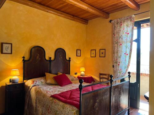 a bedroom with a large bed with a wooden headboard at Casa Ambrogina in Agliano Terme