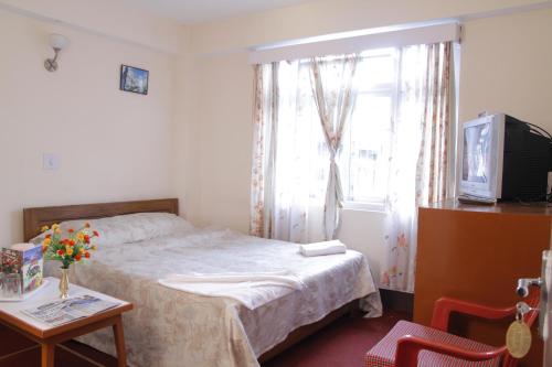 Una cama o camas en una habitación de Hotel Kasturi
