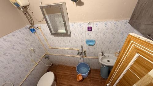 a small bathroom with a toilet and a sink at Chill Vibes in Visakhapatnam