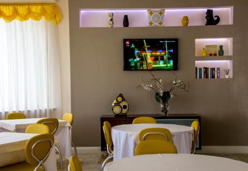 Habitación con mesas, sillas y TV. en Hotel Ristorante Sbranetta, en Rozzano
