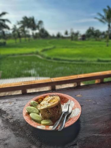 a plate of food with a sandwich and pickles at padi bungalow in Tetebatu