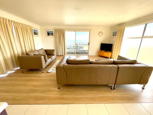 a living room with a couch and a television at Bayview Beach House Apartment No 1 in Kingscote