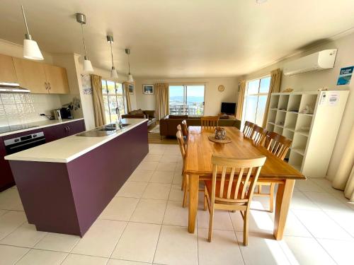 a kitchen and dining room with a wooden table and chairs at Bayview Beach House Apartment No 1 in Kingscote