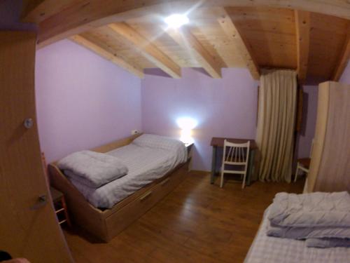 a small bedroom with a bed and a table at Cal Fuster I in Todolella